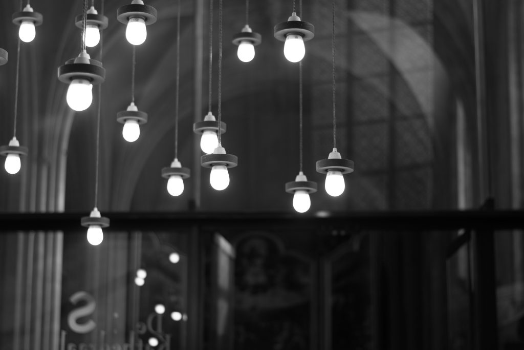 Black and white photo of hanging bulbs in a modern indoor setting, showcasing contemporary design.